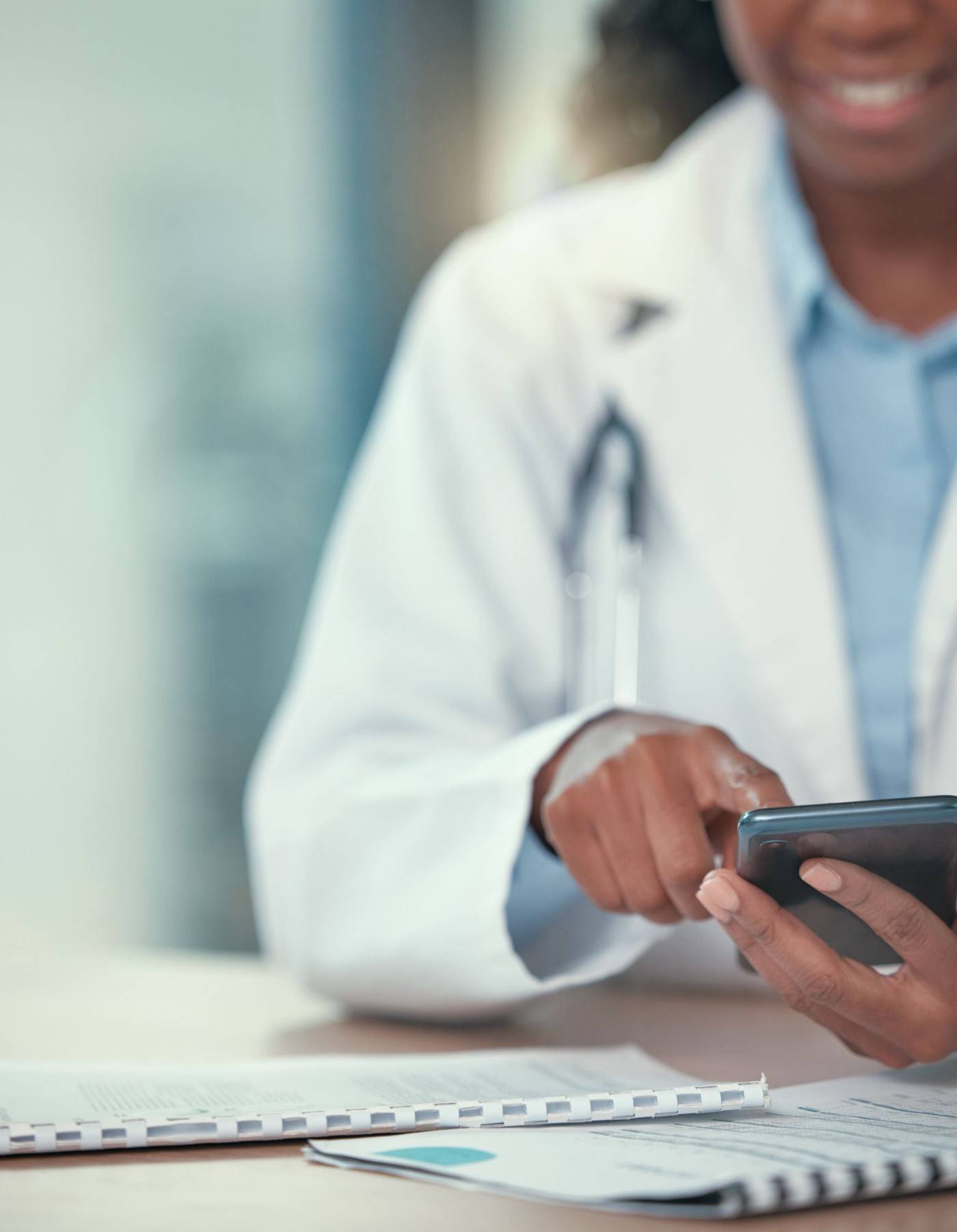 Physician reviewing practice financials on her phone at her desk