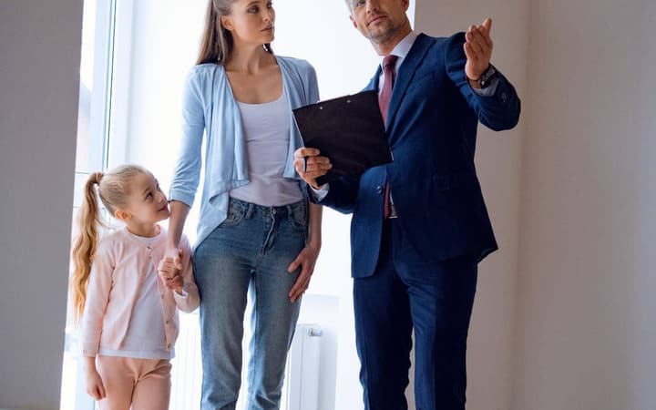 Real estate agent showing a property to a family