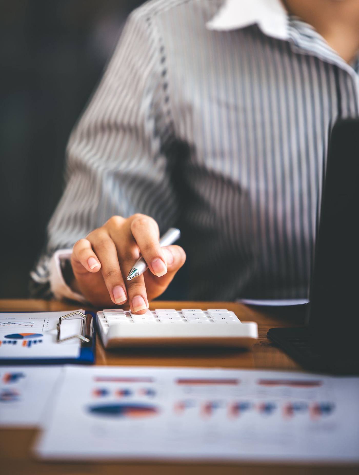 Reviewing financial reports and reconciling figures with a calculator